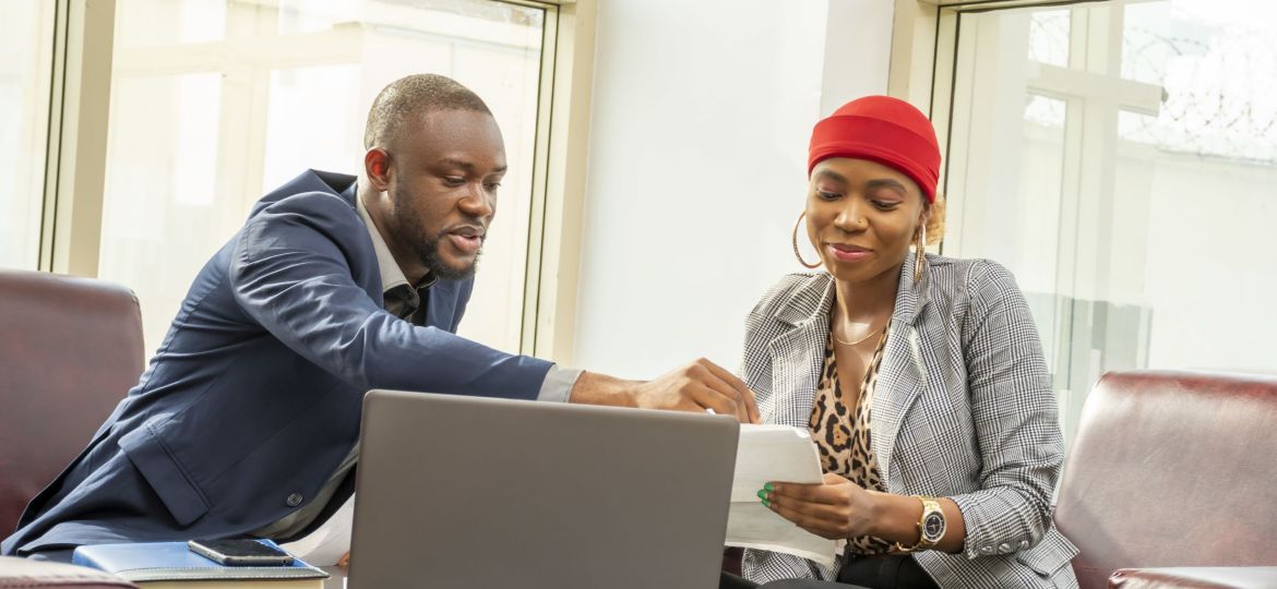 Young black businessman and woman going through some paperwork together